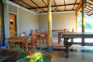 佩母德兰巴厘岛佩母德兰皇冠住宿加早餐旅馆的用餐室配有木桌和椅子