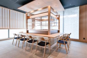 札幌Vessel Hotel Campana Susukino的一间带木桌和椅子的用餐室
