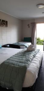 MokauMokau Motels的一间卧室设有两张床和窗户。