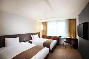 华城市普鲁米尔酒店的酒店客房设有两张床和电视。