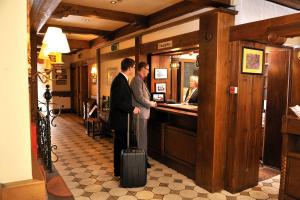 多尔马根霍特耶餐厅酒店的两个人站在酒吧,手提箱