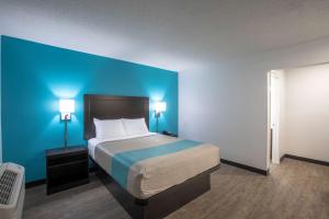 格林维尔Motel 6-Greenville, SC - I-85 Near Downtown的一间卧室设有一张蓝色墙壁的大床