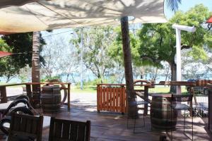 耐莉湾Arcadia Beach Guest House and Car Hire的一个带桌椅和遮阳伞的庭院