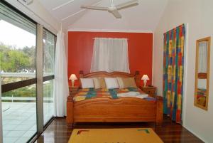 耐莉湾Arcadia Beach Guest House and Car Hire的一间卧室配有一张橙色墙壁的床