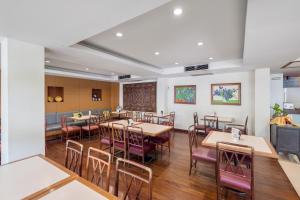 曼谷JL Bangkok Hotel的用餐室配有木桌和椅子