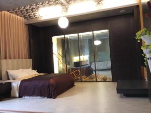 斗南海悦SPA汽车旅馆 的一间卧室配有一张床和一面大镜子