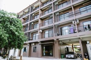 Ban Khok KrathinPJ Loft Hotel的公寓大楼外设有停车位