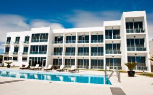 普拉亚达维多利亚阿特兰蒂达马尔酒店的一座带游泳池的大型白色建筑