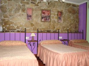 奥耶多佩尼亚萨格拉旅馆的一间卧室设有两张床和石墙