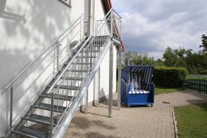 多鲁姆纽菲尔德Ferienwohnung am Schwarzen Wehl的蓝色椅子旁的白色楼梯栏杆