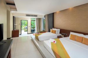 北芭堤雅The Zign Hotel Premium Villa的酒店客房设有两张床和电视。