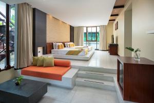 北芭堤雅The Zign Hotel Premium Villa的一间带两张床和电视的客厅