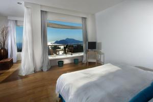 马萨鲁布朗斯黎莱斯布鲁酒店的卧室设有白色的床和大窗户