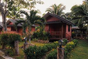 奥南海滩可可公寓度假村的一座棕榈树的红色小房子