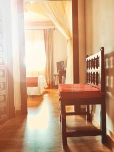 托莱多德尔卡德纳尔庄园酒店的一间带椅子和床的房间以及窗户