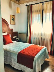 托莱多德尔卡德纳尔庄园酒店的一间卧室设有一张大床和一个窗户。