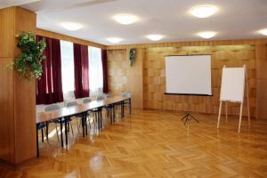 库瑞尼卡慕斯卡Ośrodek Wypoczynkowo-Szkoleniowy Perkoz的一间设有一排桌椅和屏幕的房间