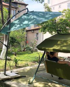 巴统Batumi Summer Hotel的坐在一把伞下椅子上的人