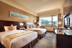 桂林桂林漓江大瀑布饭店的酒店客房设有两张床和窗户。