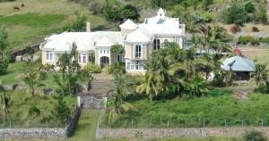 Rodrigues Island避风港旅馆的棕榈树山丘上一座白色的大房子