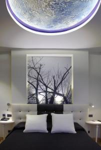奥维多坎波阿莫酒店的一间卧室,配有一张带一棵树画的床