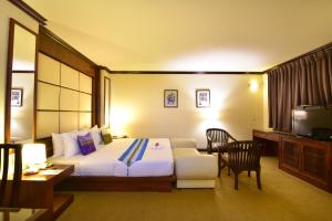 曼谷格兰德商务酒店的酒店客房带一张床、一张桌子和椅子