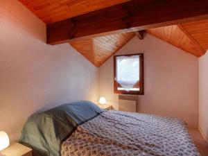 米尼赞海滩Apartment Les Landaises by Interhome的一间卧室设有床、窗户和木制天花板