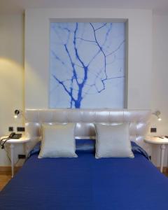 奥维多坎波阿莫酒店的一间卧室配有蓝色的床和2个白色枕头