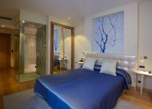 奥维多坎波阿莫酒店的一间卧室设有蓝色的床和玻璃淋浴间