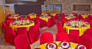 洛索亚河畔布伊特拉戈埃尔安德罗亚酒店的宴会厅设有黄色桌子和红色椅子