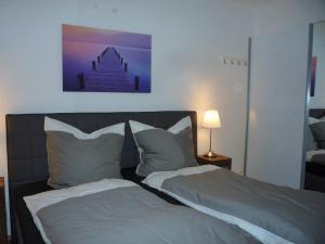 岑平Haus Vineta, Wohnung 7的一张带两个枕头的床和一张墙上的照片