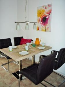 岑平Haus Vineta, Wohnung 7的餐桌、椅子和墙上的绘画
