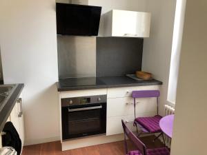 绍莱La Villa B的小厨房配有炉灶和紫色凳子