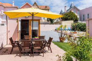 加亚新城Aguda Beach Charming House By PortoProperties4You的露台的遮阳伞下的桌椅