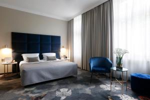 克拉科夫女王精品酒店的一间卧室配有一张大床和蓝色床头板
