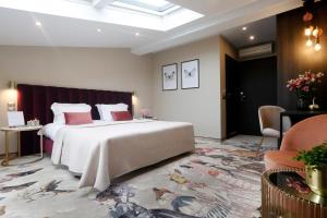 克拉科夫女王精品酒店的卧室配有一张带粉红色枕头的大床