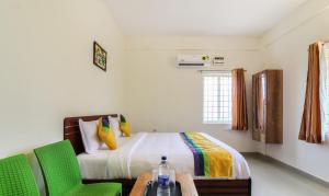 蒂鲁帕蒂Itsy By Treebo - Riyas Grand的一间卧室配有一张床和两张绿色椅子