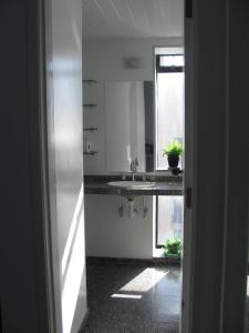 福塔莱萨贵宾伊拉塞马公寓酒店的白色的厨房设有水槽和窗户