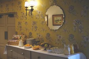 康达格林穆勒康德格林酒店的一间设有镜子和一张带食物的桌子的房间