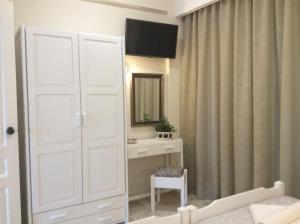 普拉塔尼亚斯玛丽亚套房公寓式酒店的卧室设有白色门、梳妆台和镜子