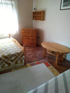福纽德Codini Ház的一间卧室配有桌子、一张床和一个梳妆台