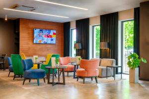 卢布林Focus Hotel Premium Lublin的一间设有五颜六色的椅子和桌子的等候室