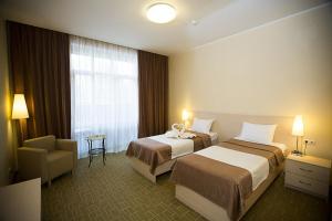 别尔茨克科罗娜酒店及SPA的酒店客房,配有两张床和椅子