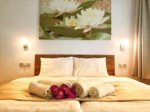 蒂萨菲赖德Boró Apartman的一间卧室配有带毛巾和鲜花的床