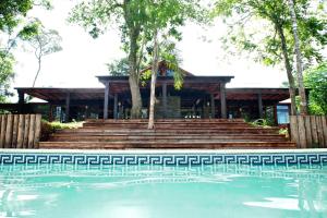 萨尔多斯德莫克纳拉米西翁摩可拿酒店 - 丛林小屋的一座带楼梯的建筑前的游泳池
