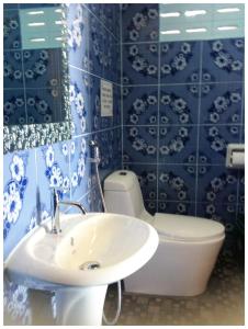 拉迈纽哈特简易别墅酒店的浴室设有水槽、卫生间和蓝色瓷砖。