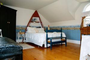 萨默赛德Bugaboo Cottages的一间卧室配有一张床和一把椅子