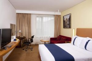 北京北京前门富力智选假日酒店的酒店客房设有一张大床和一台电视机。