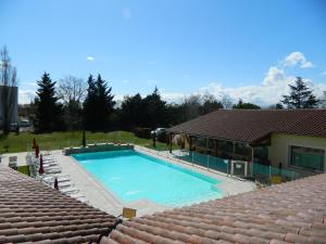 蒙代列赫Hotel Restaurant La Martiniere的一座房子旁边的大型游泳池