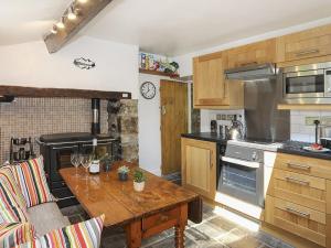 NantlleTan Meredydd的厨房配有木桌和炉灶。